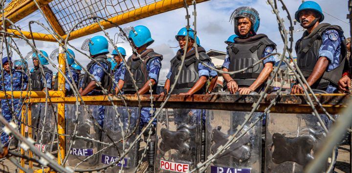 Personal de seguridad monta guardia tras barricadas durante una protesta liderada por el Comité Coordinador para la Integridad de Manipur (COCOMI), una organización de la sociedad civil meitei, cerca de Raj Bhavan en Imphal, capital del estado de Manipur, al noreste de la India.