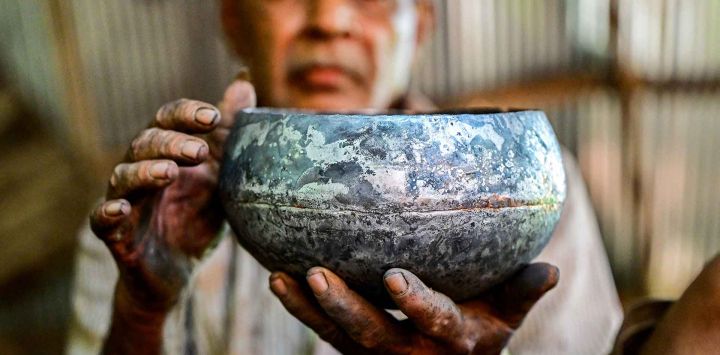 El artesano Thenuwara Badalge Sarath muestra un cuenco tradicional para pedir limosna, utilizado por monjes budistas. Foto de Ishara S. KODIKARA / AFP