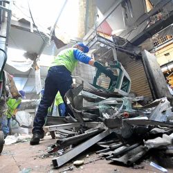 Empleados municipales retiran escombros de un pequeño local comercial afectado por un artefacto explosivo en el sector Bahía del centro de Guayaquil, Ecuador. Foto de Rodrigo BUENDIA / AFP | Foto:AFP
