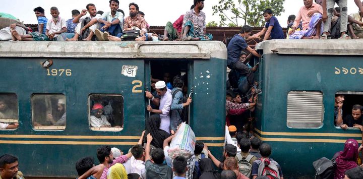 Bangladeshíes suben a un tren en una estación de ferrocarril a las afueras de Daca. Foto de MUNIR UZ ZAMAN / AFP
