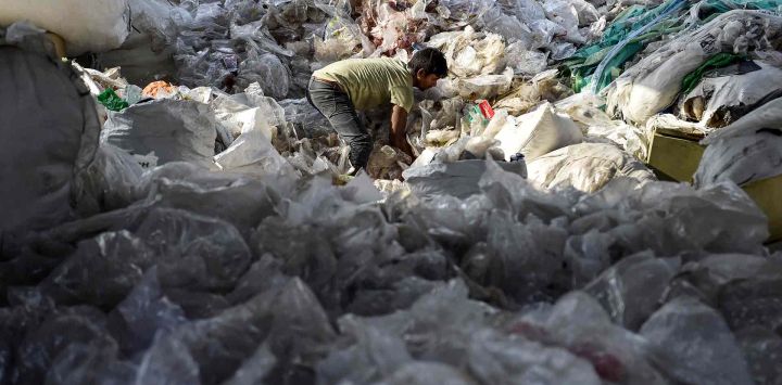 Un trabajador clasifica residuos plásticos reciclables en un almacén de Jalandhar. Foto de Shammi MEHRA / AFP
