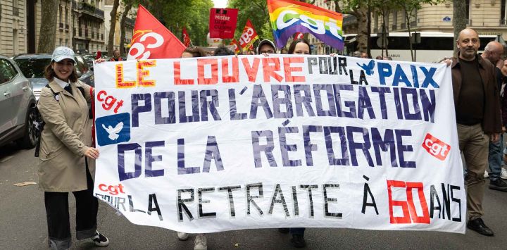 Manifestantes sostienen una pancarta con la leyenda "El Louvre por la paz y la derogación de la reforma de las pensiones" durante una manifestación contra la reforma, en París. Foto de Emma DA SILVA / AFP