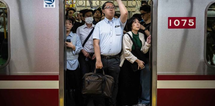 Los pasajeros viajan en tren durante la hora punta de la mañana en la estación de Shimbashi, Tokio. Foto de Philip FONG / AFP