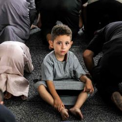 Un niño observa sentado entre los fieles musulmanes que se postran mientras realizan las oraciones matutinas del Eid al-Adha. Foto de Bashar TALEB / AFP | Foto:AFP