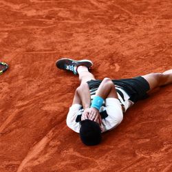 El español Carlos Alcaraz celebra tras vencer al italiano Jannik Sinner al final de su partido individual masculino en el día 15 del torneo de tenis Abierto de Francia en la cancha Philippe-Chatrier en el Complejo Roland-Garros en París. | Foto:Thibaud Moritz / AFP
