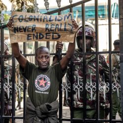 Un manifestante sostiene una pancarta mientras intenta bloquear la entrada a la sede del Servicio Nacional de Policía, exigiendo la dimisión de altos mandos tras la muerte de Albert Ojwang bajo custodia policial en Nairobi. | Foto:LUIS TATO / AFP