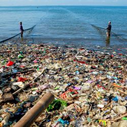 Imagen de pescadores trabajando con una red de pesca en una costa cubierta de basura plástica en la playa Sukaraja, en Bandar Lampung, en la provincia de Lampung, Indonesia. | Foto:Xinhua/Deden Isman