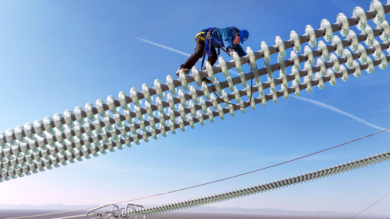 Vista aérea tomada con un dron de un trabajador operando sobre los cables del proyecto de transmisión de corriente continua de ultra alta tensión de ±800 kV Hami-Chongqing, en Hami, en la región autónoma uygur de Xinjiang, en el noroeste de China. | Foto:Xinhua/Ma Yuan