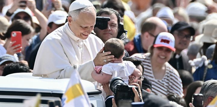 El Papa León XIV bendice a un niño a su llegada para la audiencia general semanal en la Plaza de San Pedro del Vaticano.