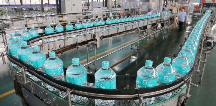 Imagen de empleados trabajando en la línea de producción de agua potable embotellada en Jiangsu Fenghai New Energy Seawater Desalination Development Co., Ltd., en Yancheng, en la provincia de Jiangsu, en el este de China.