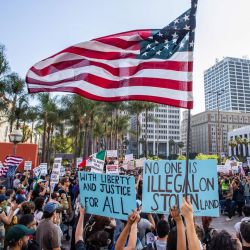 Manifestantes con pancartas y una bandera estadounidense se congregaron en Pershing Square para protestar contra las operaciones federales de inmigración en el centro de Los Ángeles. | Foto:APU GOMES / AFP