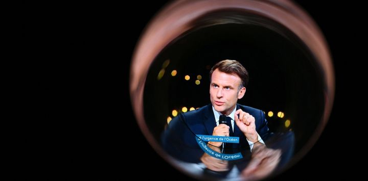 Esta fotografía de una pantalla vista a través de un tubo de plástico, tomada en Mulhouse, muestra al presidente francés, Emmanuel Macron, durante la emisión del programa de televisión "Urgencia océano: un sommet para todo cambio" del canal de televisión francés France 2, en un plató instalado en el marco de la UNOC3, la tercera Conferencia de las Naciones Unidas sobre los Océanos (UNOC), una cumbre de alto nivel sobre la conservación de los océanos celebrada en Niza, en la Riviera Francesa.