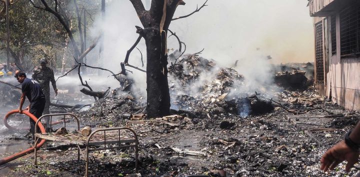 Los bomberos trabajan en el lugar donde se estrelló el vuelo 171 de Air India en una zona residencial cerca del aeropuerto de Ahmedabad.