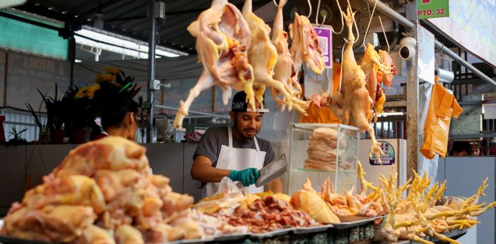 Un vendedor de pollo espera por clientes en un puesto de un mercado, en el distrito de Lurín, en el sur de Lima, Perú.