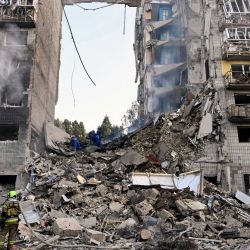 Rescatistas ucranianos realizan labores de búsqueda y rescate en un edificio residencial gravemente dañado tras el ataque con misiles rusos en Kiev, en medio de la invasión rusa de Ucrania. | Foto:GENYA SAVILOV / AFP