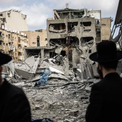 Hombres judíos ultraortodoxos inspeccionan los daños en el lugar de un ataque con misiles iraníes en Bnei Brak, al este de Tel Aviv. Irán desató una andanada de ataques con misiles contra ciudades israelíes, después de que Israel atacara objetivos militares en el interior de Irán, con ambas partes amenazando con una mayor devastación. | Foto:JOHN WESSELS / AFP