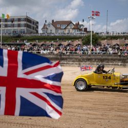 Un piloto participa en la carrera de playa "Race the Waves" a lo largo de un recorrido de 200 yardas en Bridlington South Beach, en Yorkshire, norte de Inglaterra. | Foto:OLI SCARFF / AFP
