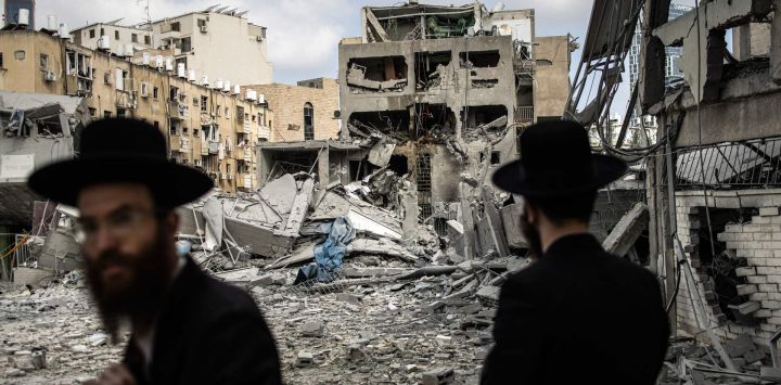 Hombres judíos ultraortodoxos inspeccionan los daños en el lugar de un ataque con misiles iraníes en Bnei Brak, al este de Tel Aviv. Irán desató una andanada de ataques con misiles contra ciudades israelíes, después de que Israel atacara objetivos militares en el interior de Irán, con ambas partes amenazando con una mayor devastación.