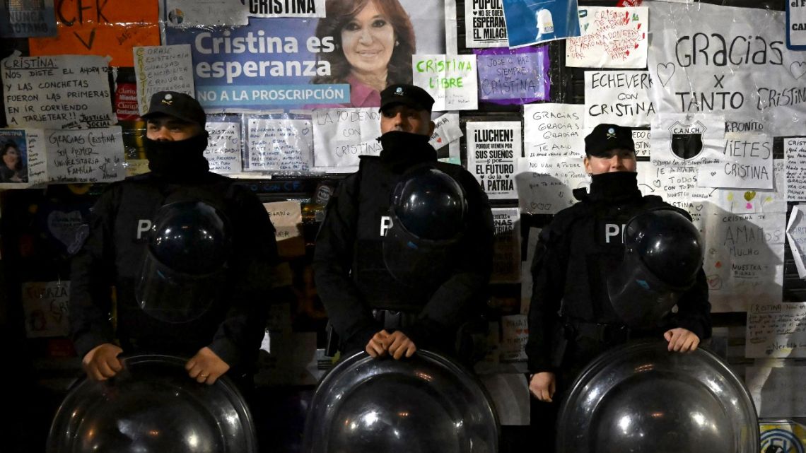 Members of the Federal Police stand guard in front of a wall with messages in support of former president Cristina Fernández de Kirchner outside her apartment building in Buenos Aires on June 20, 2025. 
