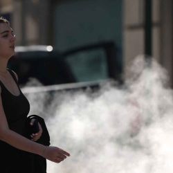 Una mujer pasa junto a una rejilla de vapor en Wall Street, mientras se emite una alerta de calor extremo para el área de Nueva York. Foto de TIMOTHY A. CLARY / AFP | Foto:AFP