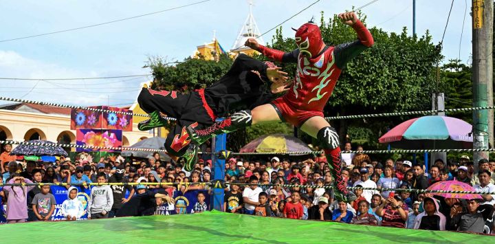 Los luchadores guatemaltecos La Diabla (R) y Dante, de la "Arena Renacer Maya" pelean en San Juan Sacatepéquez, Guatemala. Foto de JOHAN ORDÓNEZ/AFP