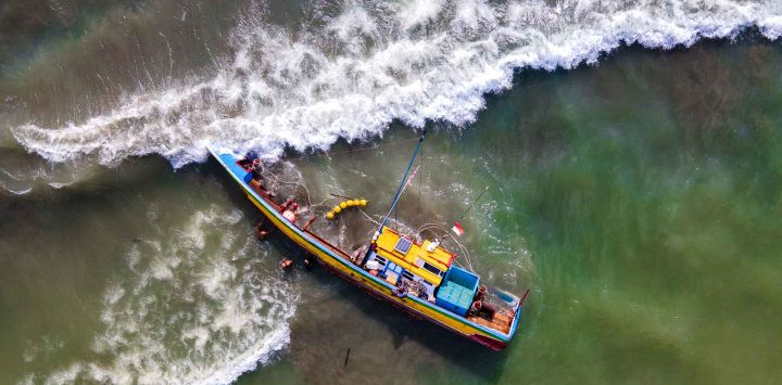 Una vista aérea muestra un barco pesquero que volcó debido a las condiciones climáticas cerca de la costa de Banda Aceh. Foto de CHAIDEER MAHYUDDIN / AFP