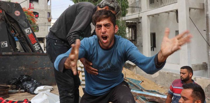  Un hombre palestino llora mientras otros transportan los cuerpos de las personas fallecidas en los ataques israelíes en Jabalia. Foto de Omar AL-QATTAA / AFP
