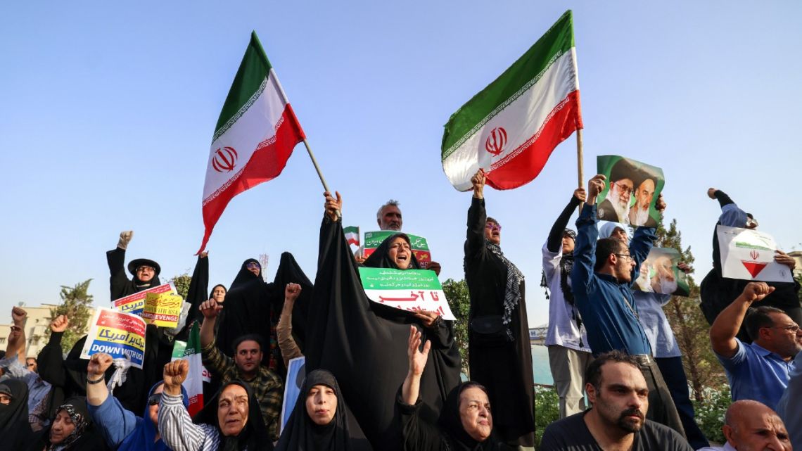Iranians chant slogans and wave national flags as they celebrate a ceasefire between Iran and Israel at Enghlab Square in the capital Tehran on June 24, 2025. A fragile ceasefire in the Iran-Israel war appeared to be holding on June 24, after 12 days of strikes that saw Israel and the United States pummel the Islamic republic's nuclear facilities. 