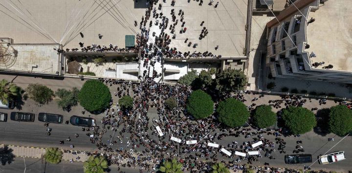 Dolientes cargando los ataúdes de los fallecidos en un atentado suicida hace dos días, a su llegada a la Iglesia de la Santa Cruz, en el barrio de al-Qassaa de Damasco. Foto de Bakr ALKASEM / AFP