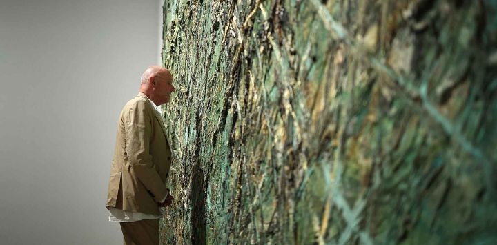 El artista alemán Anselm Kiefer posa con "Nevermore" (2014) durante la exposición de arte "Kiefer / Van Gogh" en la Royal Academy of Arts de Londres. Foto de HENRY NICHOLLS / AFP