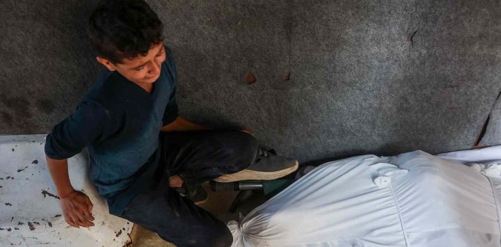 Un niño llora junto al cuerpo de un hombre asesinado cerca del cruce fronterizo de Zikim. Gaza. Foto de Omar AL-QATTAA / AFP
