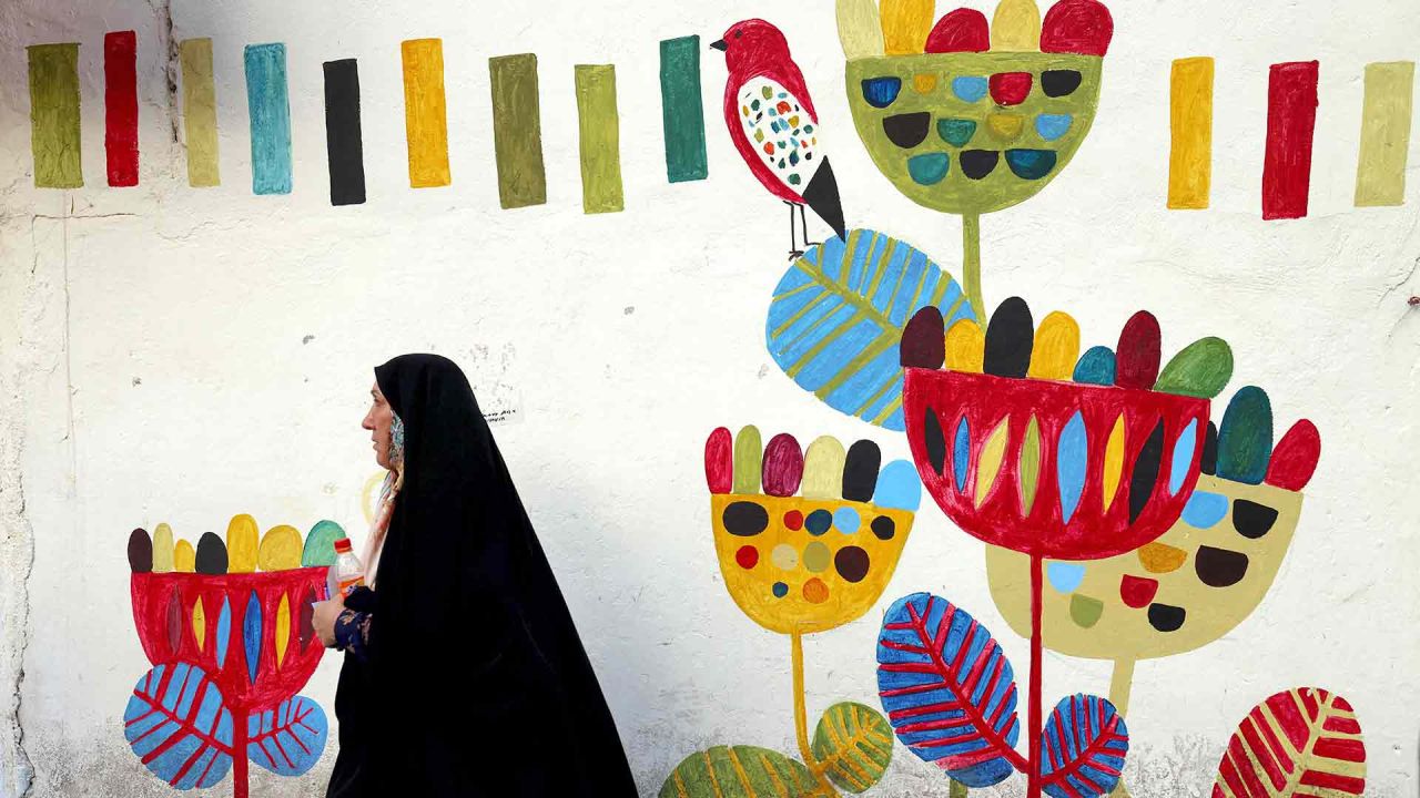  Una mujer iraní pasa junto a un mural en la plaza Enghlab de la capital, Teherán. Foto de ATTA KENARE / AFP | Foto:AFP