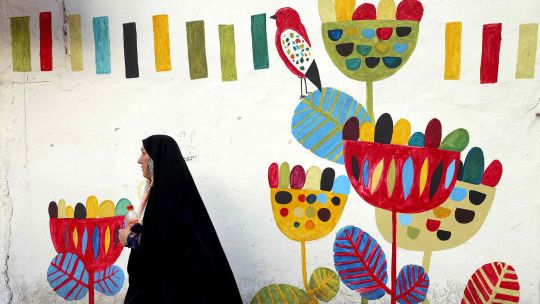 FOTOGALERIA  Una mujer iraní pasa junto a un mural