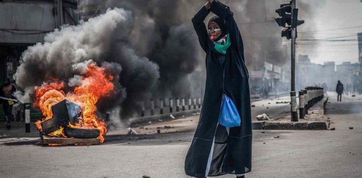Un manifestante reacciona frente a una barricada en llamas en el centro de Nairobi, para conmemorar un año de la caída del parlamento. Foto de Luis TATO / AFP