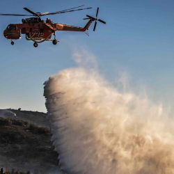 Un helicóptero de extinción de incendios Sikorsky S-64 Skycrane lanza agua sobre un incendio forestal cerca de Thymari. Foto de Aris MESSINIS / AFP | Foto:AFP