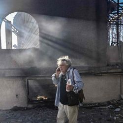 Un hombre habla por teléfono junto a una casa quemada tras un incendio forestal en Thymari, al sureste de Atenas. Foto de Aris MESSINIS / AFP | Foto:AFP
