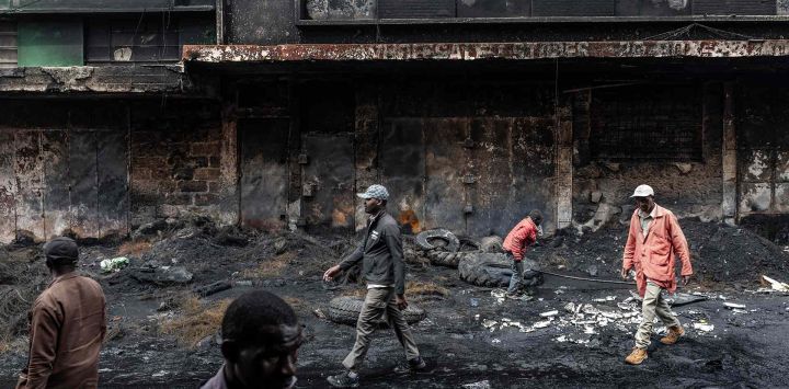 Residentes pasan frente a un centro comercial vandalizado e incendiado en Nairobi. Foto de Luis TATO / AFP