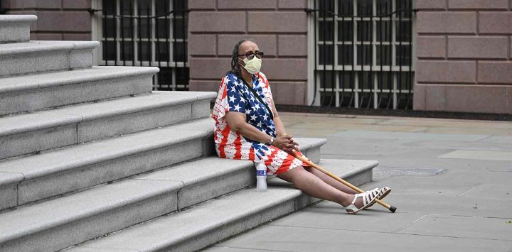 Un partidario del alcalde de Nueva York, Eric Adams, se sienta frente al Ayuntamiento mientras escucha su discurso de campaña. Foto de ANGELA WEISS / AFP