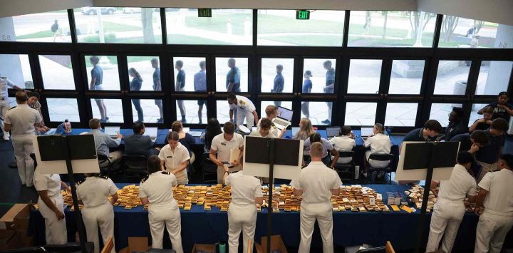 Los estudiantes de primer año ingresan al edificio para registrarse durante el Día de Inducción en la Academia Naval de los Estados Unidos. Foto de Kayla Bartkowski /AFP