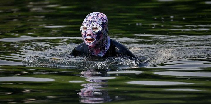 Una persona con protección solar nada en un río de Pekín. Foto de Wang Zhao / AFP