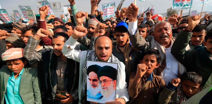 Un hombre sostiene un cartel con los retratos del difunto líder supremo de Irán, el ayatolá Ruhollah Jomeini. Foto de Mohammed HUWAIS / AFP