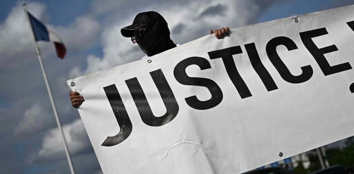 Un manifestante sostiene una pancarta durante una concentración para conmemorar los dos años de la muerte de Nahel Merzouk. Foto de JULIEN DE ROSA / AFP