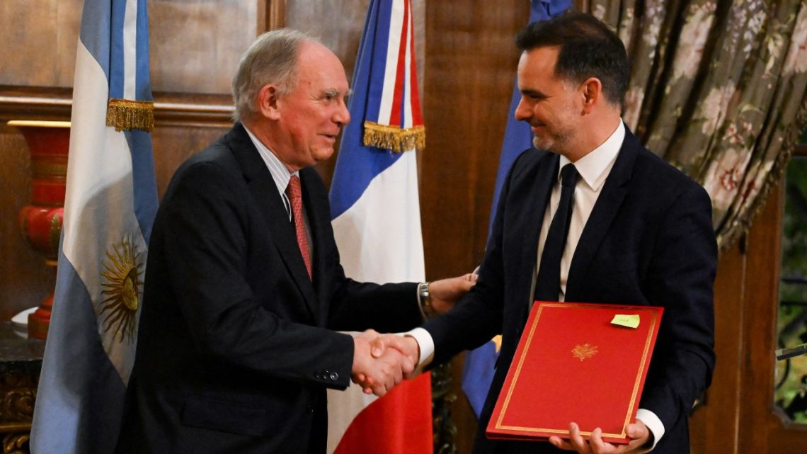 France's Delegate Minister for Foreign Trade and French Nationals Abroad Laurent Saint-Martin (right) shakes hands with Argentina's Mining Secretary Luis Lucero (left), during the signing of a memorandum of understanding on critical minerals between France and Argentina at the French Embassy in Buenos Aires on June 27, 2025. 