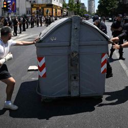 Un manifestante intenta impedir que la policía retire un contenedor de basura en Belgrado. Foto de OLIVER BUNIC / AFP | Foto:AFP