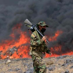Un miembro de las fuerzas de seguridad hutíes monta guardia mientras se incendian estupefacientes y drogas ilegales en Saná. Foto de Mohammed HUWAIS / AFP | Foto:AFP