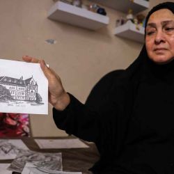 La madre del artista visual palestino Frans al-Salmi sostiene un dibujo realizado por el fotoperiodista Ismail Abu Hatab. Foto de BASHAR TALEB / AFP | Foto:AFP