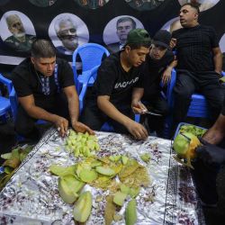 Voluntarios cortan fruta para distribuirla mientras iraquíes chiítas participan en una procesión por la calle Al-Kifah, en el centro de Bagdad. Foto de AHMAD AL-RUBAYE / AFP | Foto:AFP