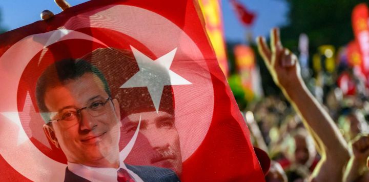 Un simpatizante sostiene una bandera del alcalde detenido de Estambul, Ekrem Imamoglu. Estambul. Foto de Yasin AKGUL / AFP