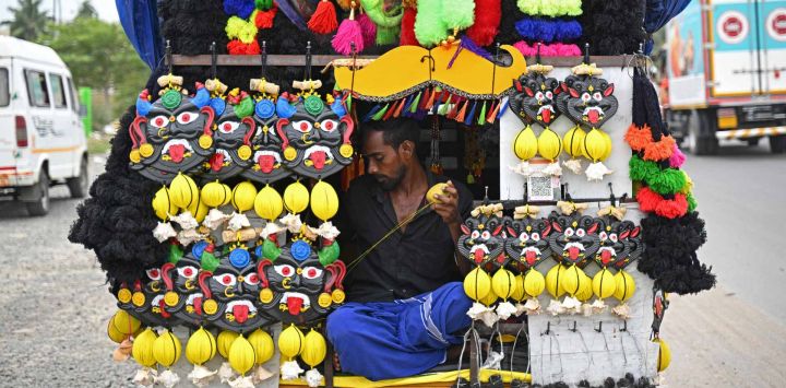 Un hombre prepara máscaras de demonio que suelen exhibirse en los hogares. Foto de R. Satish BABU / AFP