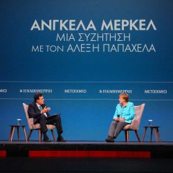 La excanciller alemana Angela Merkel, conversa con Alexis Papahelas, editor jefe del periódico Kathimerini, durante la presentación de su libro  | Foto:AFP